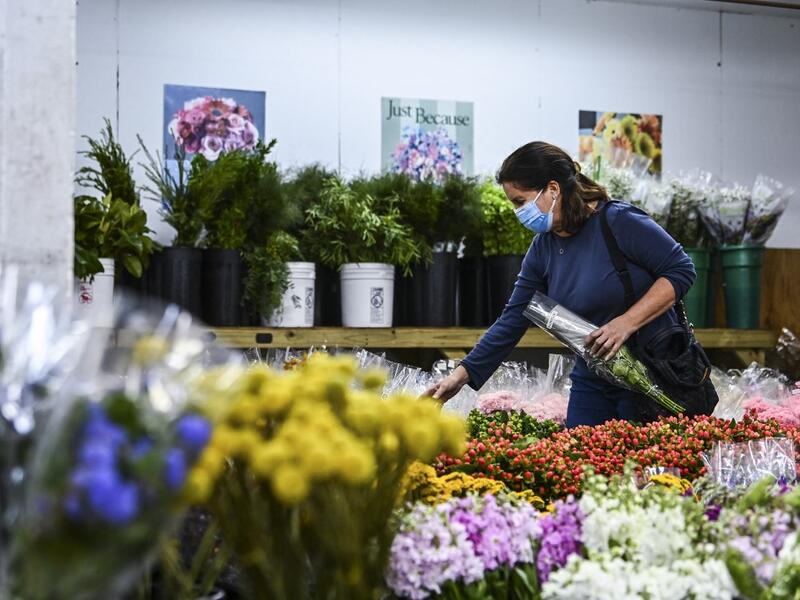 A woman buys flowers from Miami’s oldest florist, Berkeley Florist Supply, on February 13, 2021. The flower market was started in 1947. The President of Berkeley Florist, Morey Moss, says he has been experiencing overwhelming sales in 2021 after his business was badly hit by the pandemic. CHANDAN KHANNA / AFP