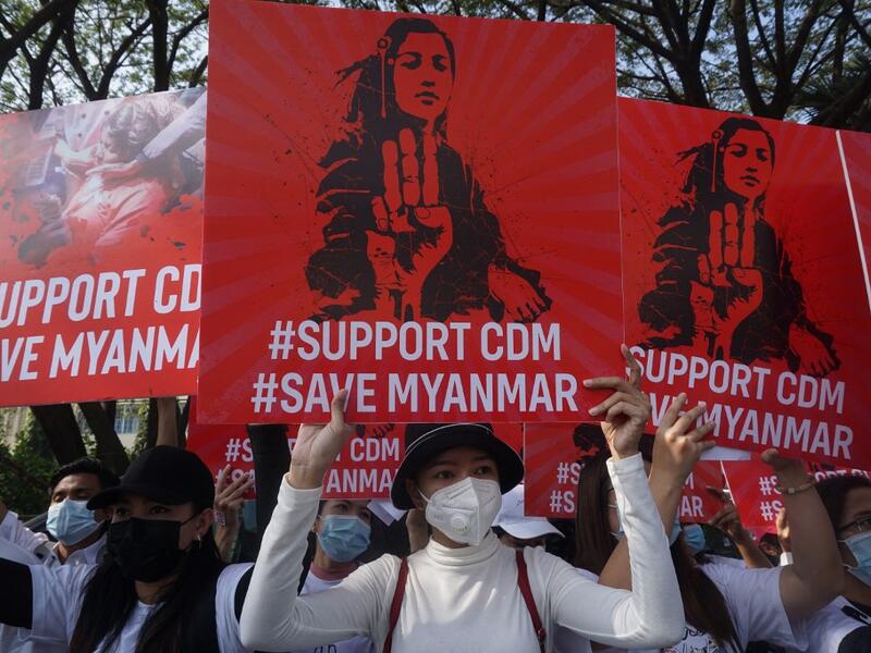 Protesters hold up signs supporting the Civil Disobedience Movement (CDM) during a demonstration against the military coup in Yangon on February 15, 2021. Sai Aung Main / AFP