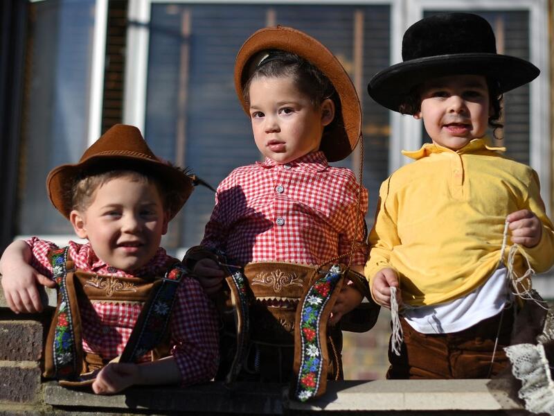 Young children dressed in costume in celebration of the Jewish holiday of Purim, pose for a photograph outside a house in the Orthodox Jewish neighborhood of Stamford Hill in north London on February 26, 2021. The carnival-like Purim holiday is celebrated with parades and costume parties to commemorate the deliverance of the Jewish people from a plot to exterminate them in the ancient Persian Empire 2,500 years ago, as recorded in the Biblical Book of Esther. DANIEL LEAL-OLIVAS / AFP