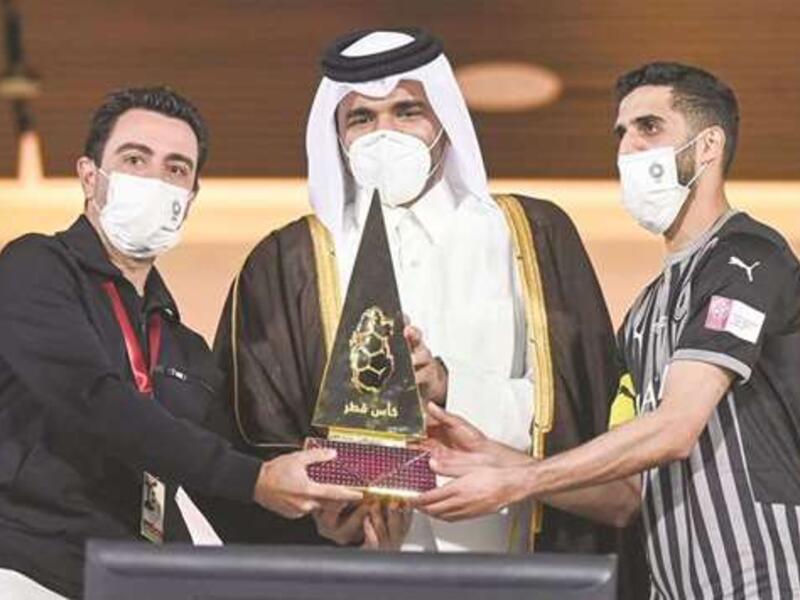 Sheikh Joaan bin Hamad al-Thani presents the Qatar Cup trophy to Al Sadd captain Hassan al-Haydos (right) and coach Xavi Hernandez (left). (Photo: Noushad Thekkayil)