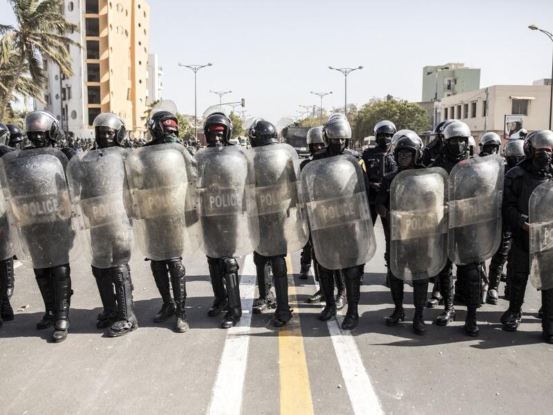 Police officers take their positions during a protest in Dakar on March 8, 2021, after the country's opposition leader Ousmane Sonko was charged with rape. Usually considered a beacon of stability in a volatile region, deadly clashes between opposition supporters and security forces have rocked the West African state. JOHN WESSELS / AFP
