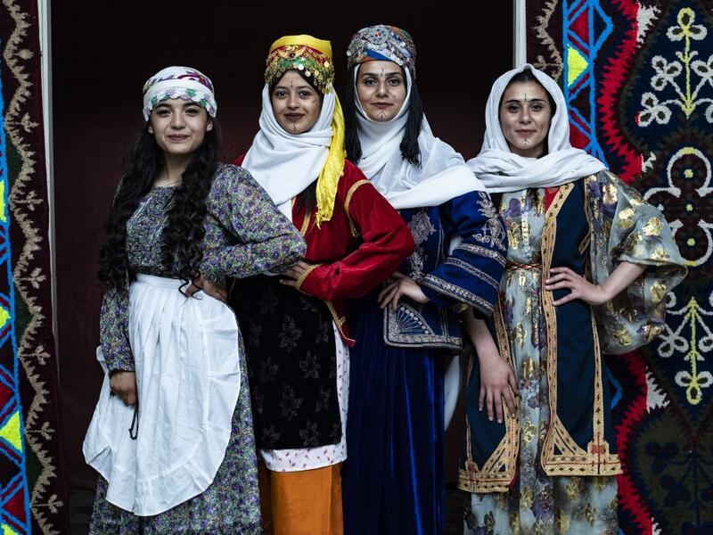 Syrian Kurdish women in traditional attire pose 