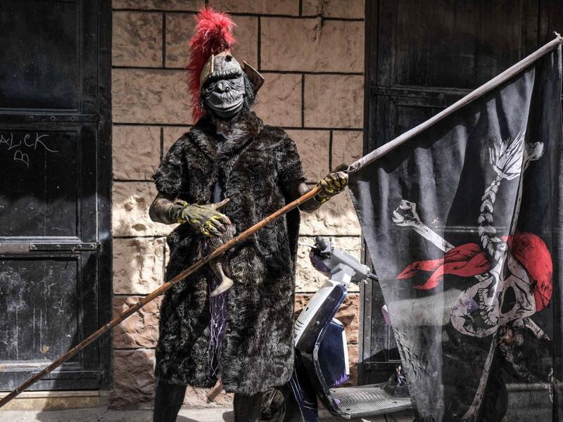 A carnival participant dressed in costume poses for a picture 
