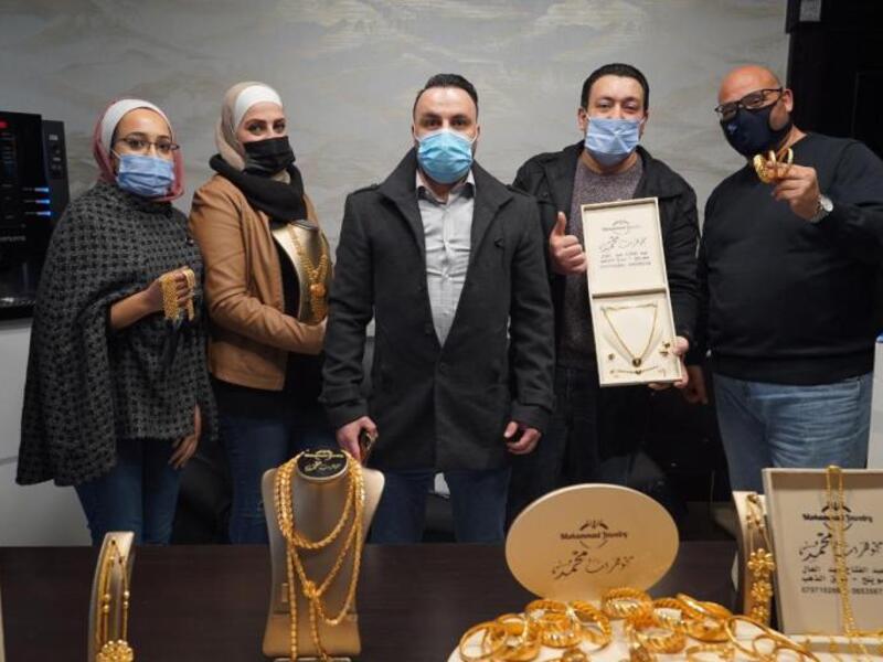 أحمد أبو سنينة يتوسط موظفيه وأكوام من الذهب