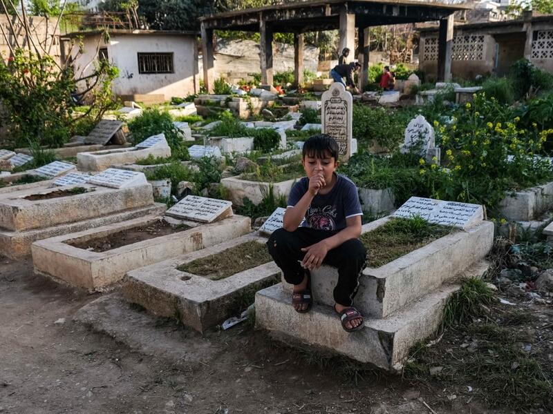A boy sits on a grave in the Ghoraba (Strangers) cemetery