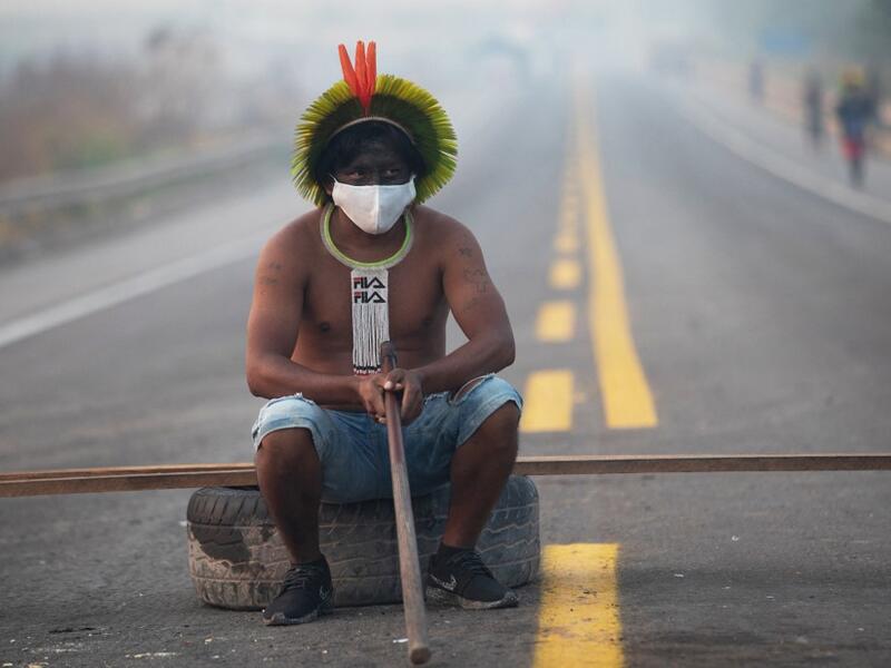  In this file photo taken on August 18, 2020 a member of the Kayapo tribe sits after they blocked highway BR163 during a protest on the outskirts of Novo Progresso in Para State, Brazil