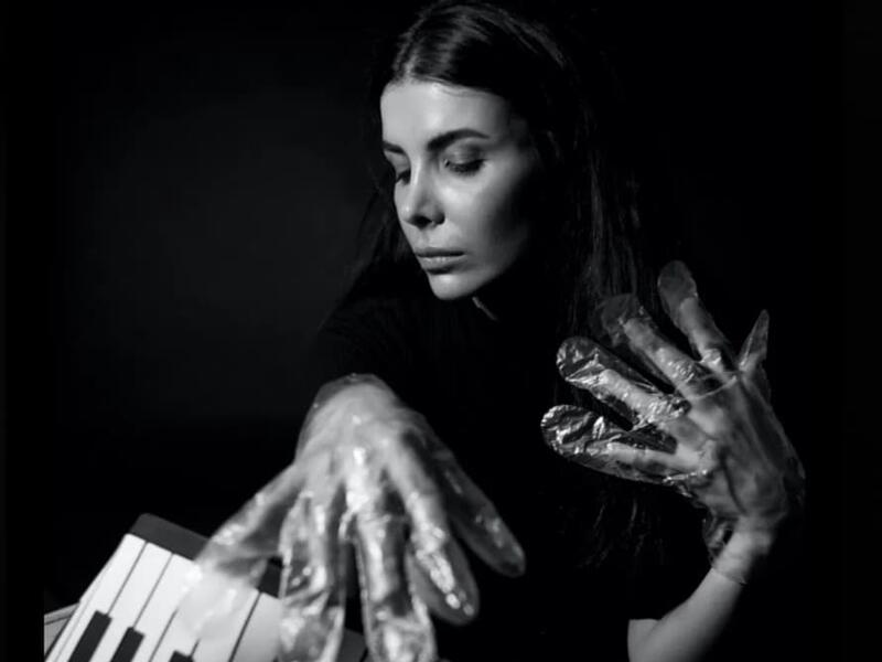 A musician in foil gloves is playing an instrument