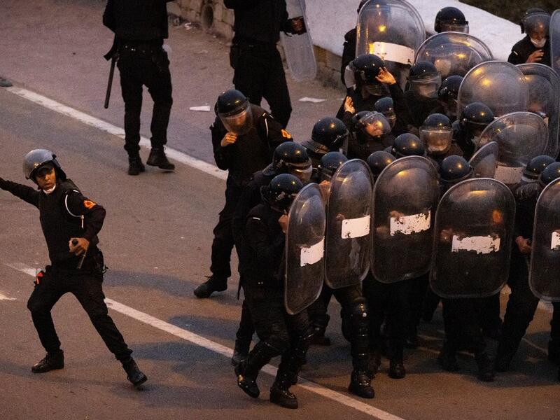 A Moroccan riot police throws a rock back at migrants during light clashes in the northern town of Fnideq, close to the border between Morocco and Spain's North African enclave of Ceuta on May 19, 2021. Migrants were still trying to cross from Morocco into the Spanish enclave of Ceuta on May 19, 2021, after a record 8,000 people poured over the border this week, escalating tensions between Rabat and Madrid. Some 5,600 migrants had already been sent back