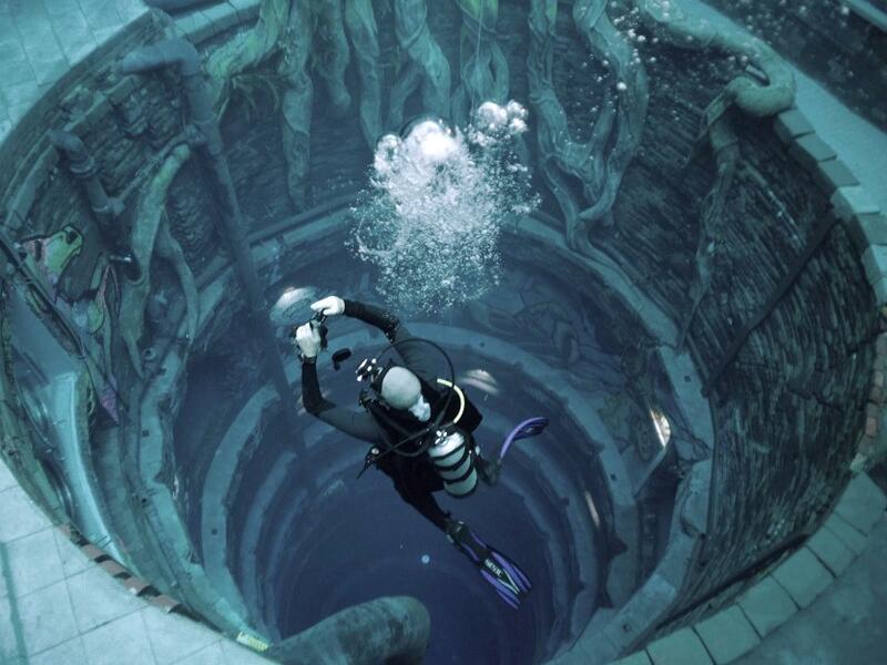 A diver experiences Deep Dive Dubai, the deepest swimming pool in the world reaching 60m, in the United Arab Emirates, on July 10, 2021. The city of superlatives, with the world's tallest tower among its many records, Dubai now has the deepest swimming pool on the planet complete with a "sunken city" for divers to explore. GIUSEPPE CACACE / AFP