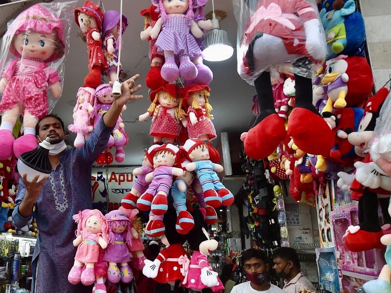 A shopkeeper installs a lightbulb outside his shop waiting for customers to shop after the government loosened a lockdown imposed as a preventive measure against the Covid-19 coronavirus ahead of the Muslim festival of Eid al-Adha in Dhaka on July 16, 2021. Munir Uz zaman / AFP