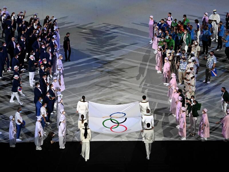 The Olympic flag is carried during the opening ceremony of the Tokyo 2020 Olympic Games, at the Olympic Stadium