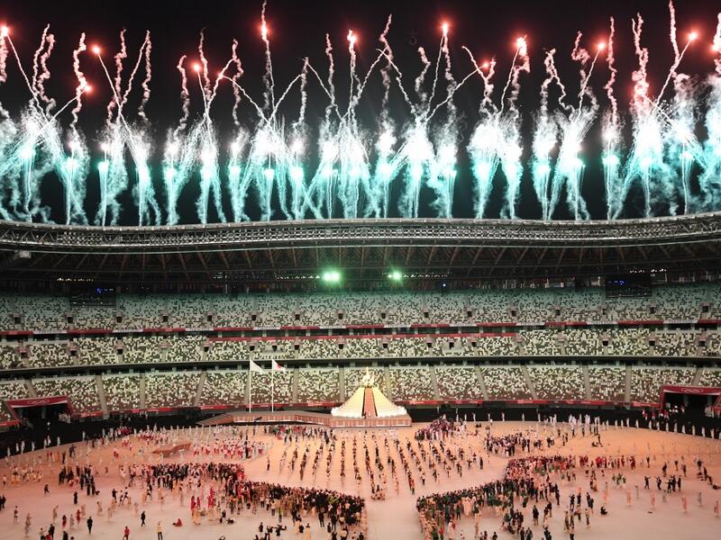 Fireworks go off around the Olympic Stadium after the lighting of the Olympic Flame during the opening ceremony of the Tokyo 2020 Olympic Games