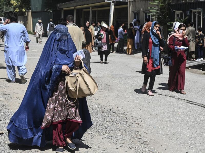 A woman wearing a burqa arrives to submit a passport application at an office in Kabul on July 25, 2021. Dozens begin lining up at the passport office in Kabul before dawn most days, and by eight in the morning the queue already stretches for a good hundred metres.