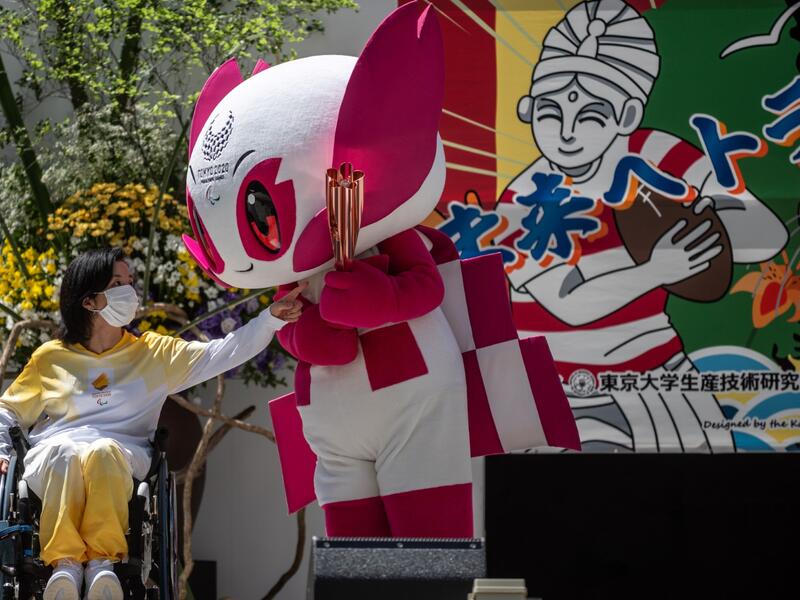 Tokyo 2020 torch relay ambassador Aki Taguchi interacts with the Tokyo 2020 Paralympic mascot Someity during a "flame gathering event" for the Tokyo 2020 Paralympic Torch Relay at the Metropolitan Government Building in Tokyo on August 20, 2021, ahead of the start of the Paralympic Games on August 24. 