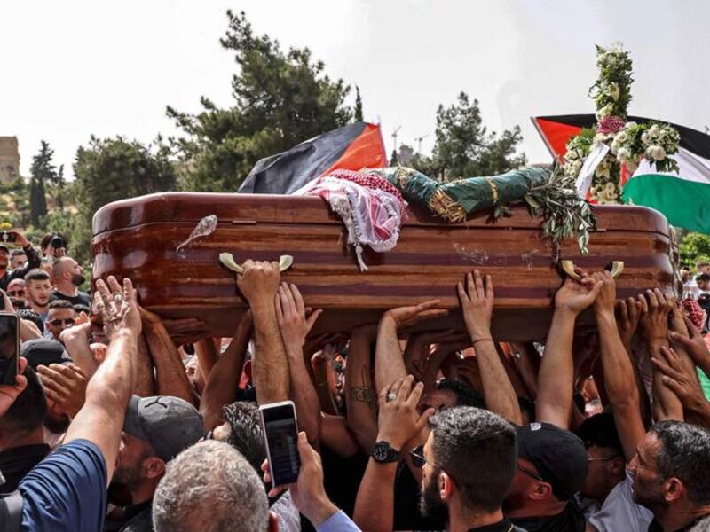 Palestinian mourners carry the casket of slain Al-Jazeera journalist 