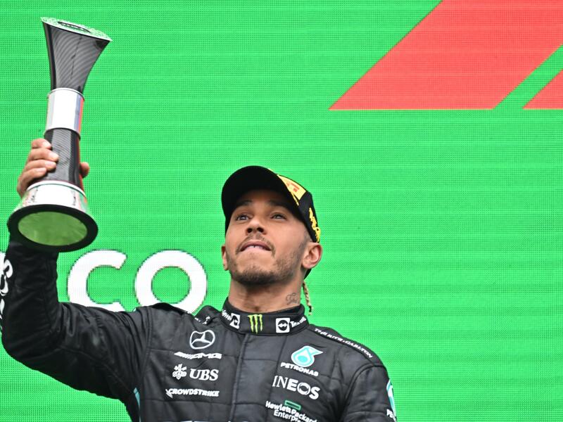 Mercedes' British driver Lewis Hamilton celebrates with the trophy on the podium after the Formula One Hungarian Grand Prix at the Hungaroring in Mogyorod near Budapest, Hungary, on July 31, 2022. (Photo by Attila KISBENEDEK / AFP)