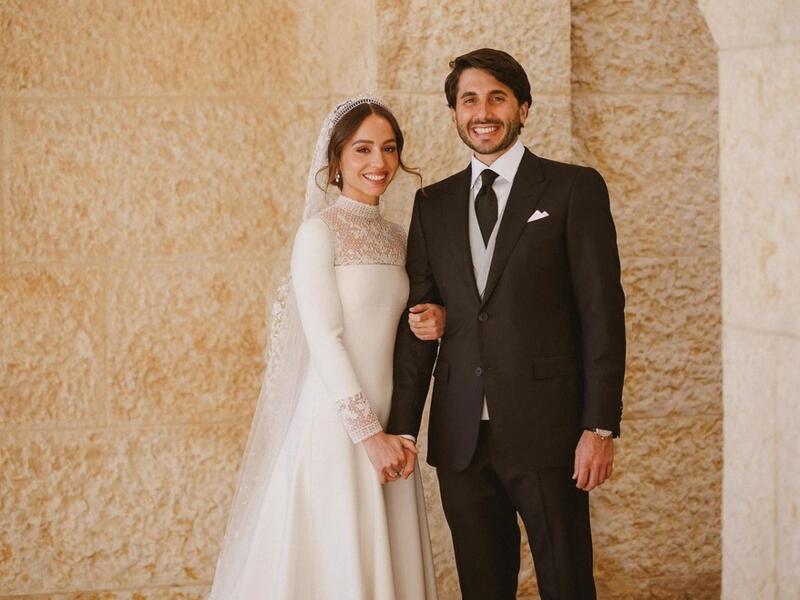 ارتدت الأميرة إيمان ثوب زفاف دانتيل بأكمام طويلة من دار ديور - Dior وتاج شوميه يقال إنه يخص جدتها الأميرة منى الحسين.