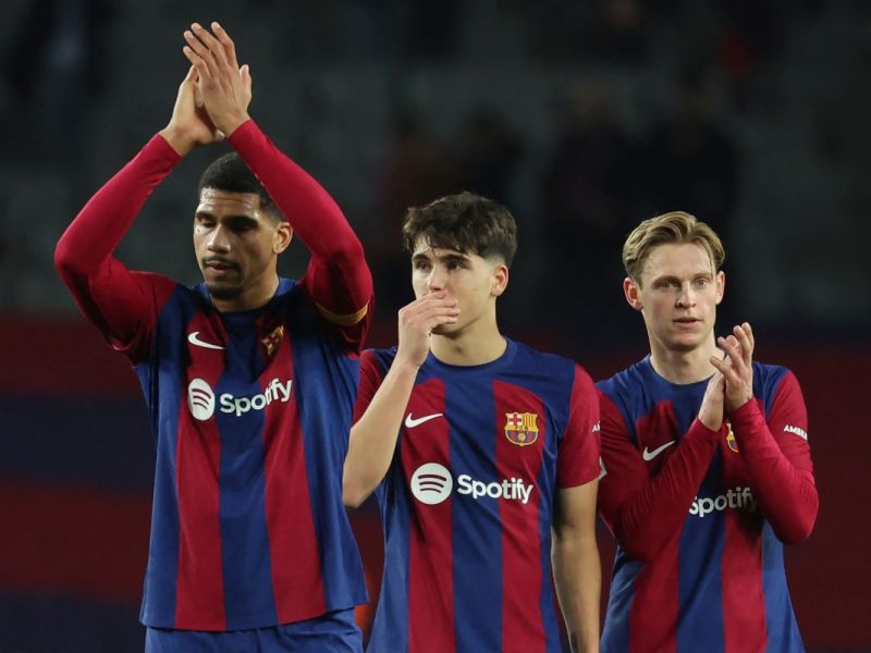 Barcelona's Uruguayan defender #04 Ronald Araujo (L) claps, next to Barcelona's Spanish defender #33 Pau Cubarsi and Barcelona's Dutch midfielder #21 Frenkie de Jong (R) at the end of during the Spanish league football match between FC Barcelona and CA Osasuna at the Estadi Olimpic Lluis Companys in Barcelona on January 31, 2024. (Photo by LLUIS GENE / AFP)