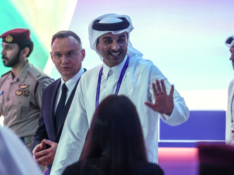 Qatar's Emir, Sheikh Tamim bin Hamad Al-Thani (R) waves as he walks alongside Poland's President Andrzej Duda (C) at the Qatar Economic Forum in Doha on May 14, 2024. (Photo by KARIM JAAFAR / AFP)