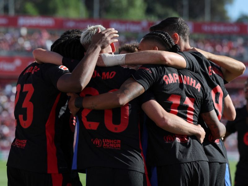 Barcelona's Spanish forward #20 Daniel Olmo celebrates with teammates scoring his team's third goal during the Spanish league football match between Girona FC and FC Barcelona at the Montilivi stadium in Girona on September 15, 2024. (Photo by LLUIS GENE / AFP)