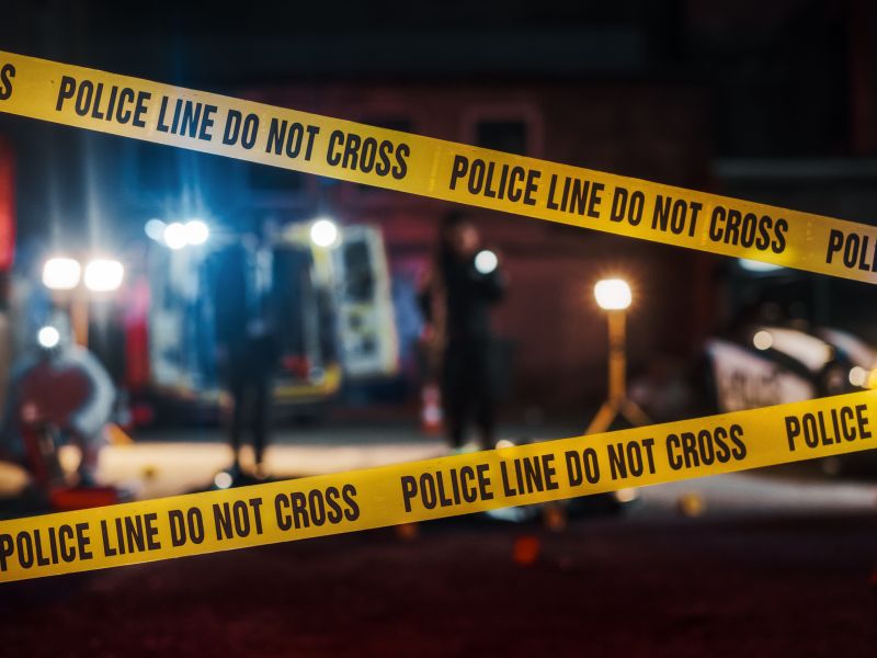 Crime Scene at Night: Crime Scene Investigation Team Working on a Murder. Female Police Officer Briefing Detective on the Victim's Body. Forensics and Paramedics Working. Cinematic Shot