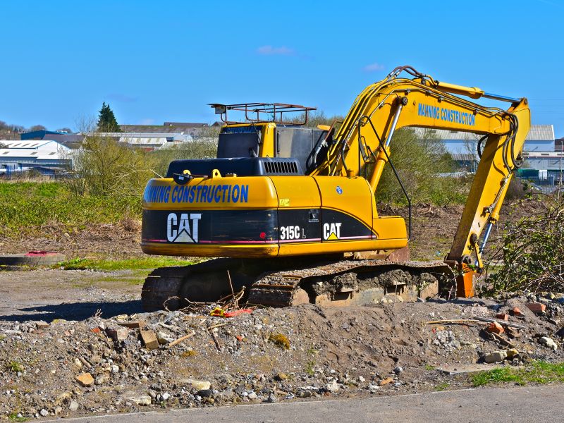 Bridgend. County Borough of Bridgend / Wales UK - 3/24/2019: New building site on the outskirts of Bridgend. A Caterpillar 315CL hydraulic excavator.