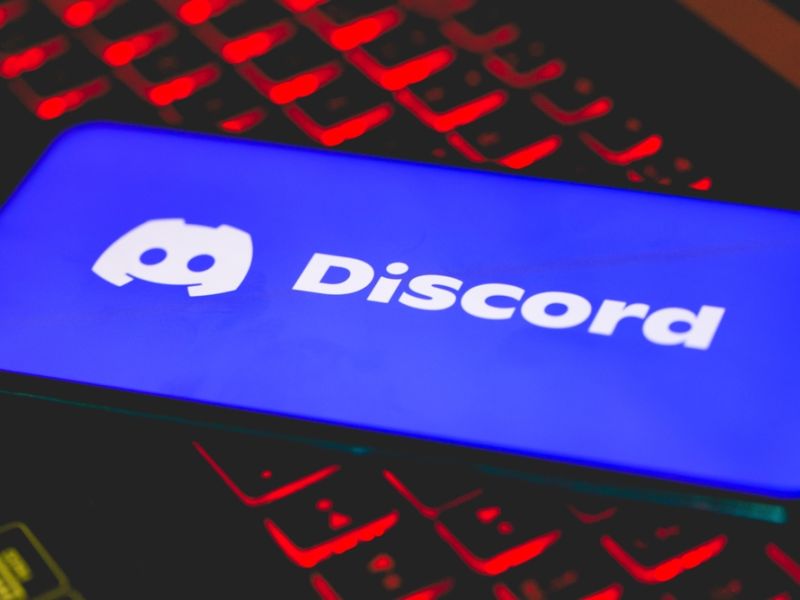 The Discord logo on a cell phone screen resting on top of a laptop keyboard. (Shutterstock) Discord