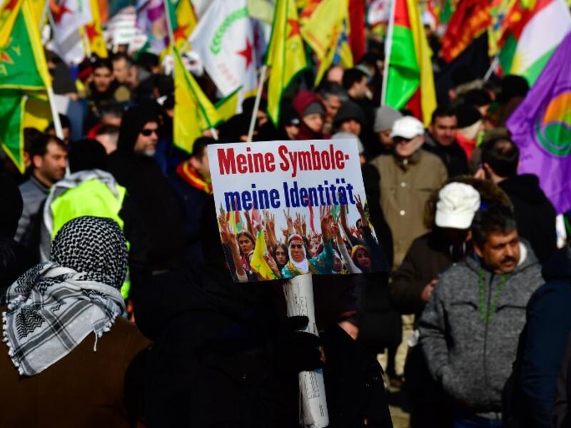 Protesters hold flags and posters reading "My symbols - my identity" during a demonstration of Kurdish groups to protest against Turkey's offensive against Kurds in Syria's Afrin region, on Mar. 3, 2018 in Berlin. 
(John MACDOUGALL / AFP)