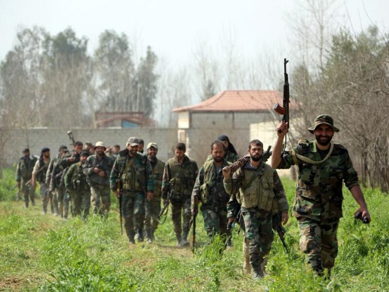 Syrian regime forces are pictured in the town of Aftris, west of the rebel-held town of Saqba, in the besieged Eastern Ghouta region on the outskirts of the capital Damascus, on Mar.10, 2018.  (AFP)