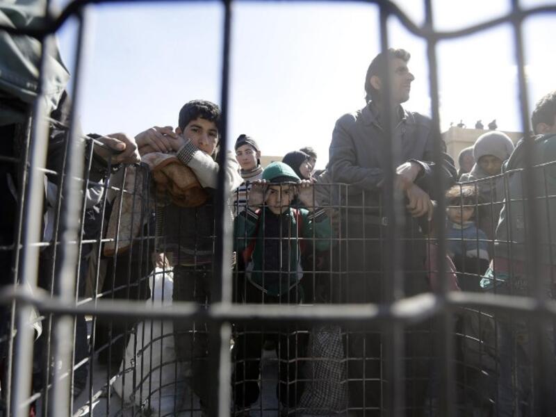 Syrian civilians, evacuated from rebel-held areas in the Eastern Ghouta, gather at a school in the regime-controlled Hosh Nasri, on the northeastern outskirts of the capital Damascus on Mar.16, 2018, ahead of being relocated to other areas. (LOUAI BESHARA / AFP)