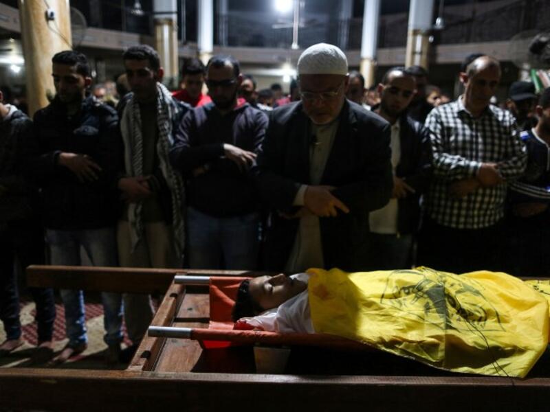 Relatives of 15-year-old Palestinian Mohammed Ibrahim Ayoub, who was shot and killed by Israeli security forces during clashes along the Israel-Gaza border, pray over his body during his funeral in Beit Lahia in the northern Gaza strip on April 20, 2018. (STRINGER / AFP)