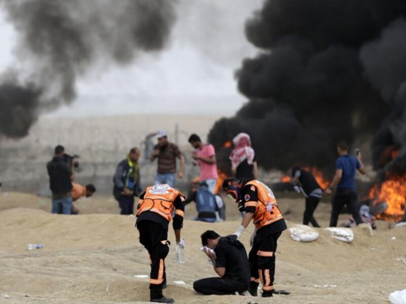 Palestinian protester react to teargas fumes during clashes with Israeli forces along the border with the Gaza strip east of Gaza City on May 4, 2018, on the sixth straight Friday of mass demonstrations calling for the right to return to their historic homelands. (MAHMUD HAMS / AFP)