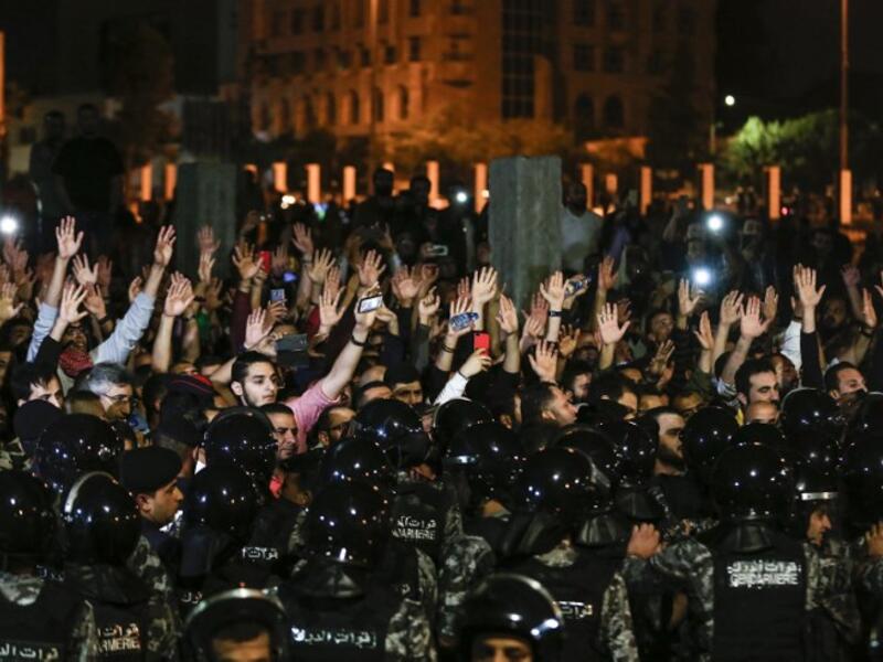 Jordanian protesters raise their hands in before members of the gendarmerie and security forces during a demonstration outside the Prime Minister's office in the capital Amman late on June 2, 2018.
Khalil MAZRAAWI / AFP