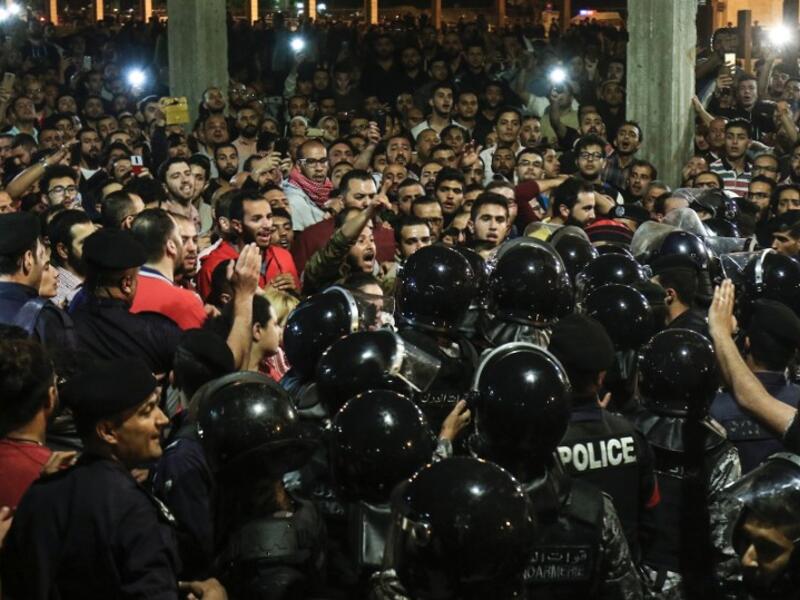 Jordanian protesters shout slogans before members of the gendarmerie and security forces during a demonstration outside the Prime Minister's office in the capital Amman late on June 2, 2018/AFP