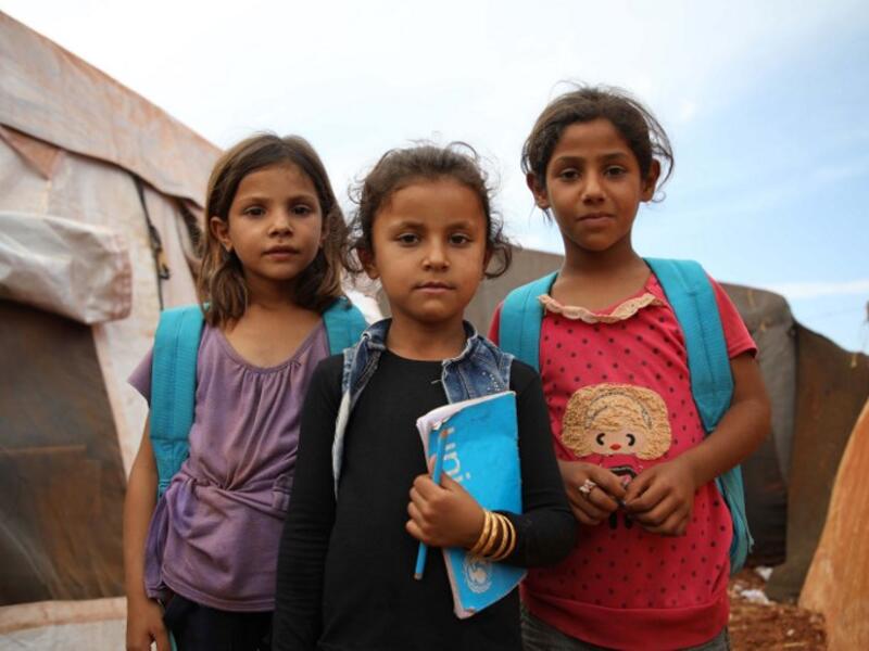 Syrian children who fled with their families from the northern countryside of Hama, pose in the yard of the makeshift school of "Zuhur al-Mustaqbal" (in Arabic "Flowers of the Future") in al-Jeneinah camp for displaced people in the village of Atme, in Syria's mostly rebel-held northern Idlib province, on October 1, 2018. Aaref WATAD / AFP