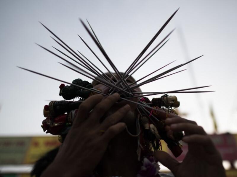 A devotee of the Loem Hu Thai Su shrine has multiple skewers pierced through his cheeks during the annual Vegetarian Festival in Phuket on October 12, 2018. Jewel SAMAD/AFP