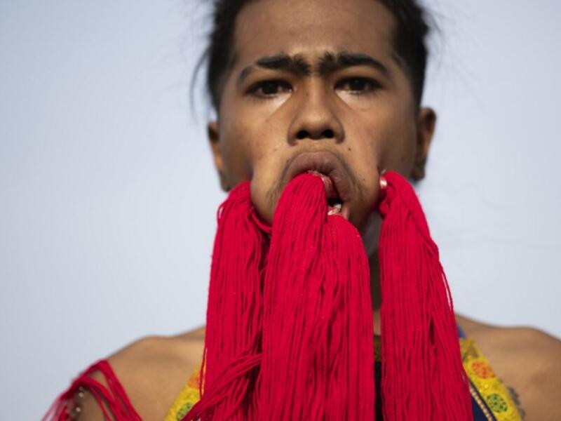 A devotee of the Loem Hu Thai Su shrine parades with coloured yarn through large piercings in his face during the annual Vegetarian Festival in Phuket on October 12, 2018. Jewel SAMAD/AFP