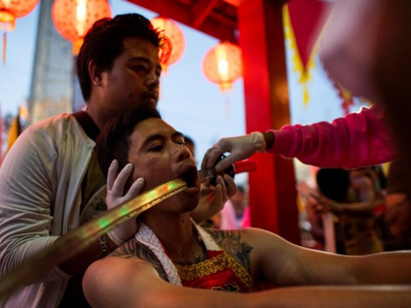 A devotee of the Loem Hu Thai Su shrine has a sword pierced through his cheek during the annual Vegetarian Festival in Phuket on October 12, 2018. Jewel SAMAD/AFP