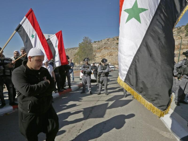 Israeli security forces stand guard as Druze men protest against municipal elections in front of a polling centre in the village of Majdal Shams in the Israeli-annexed Golan Heights on October 30, 2018. (JALAA MAREY / AFP)