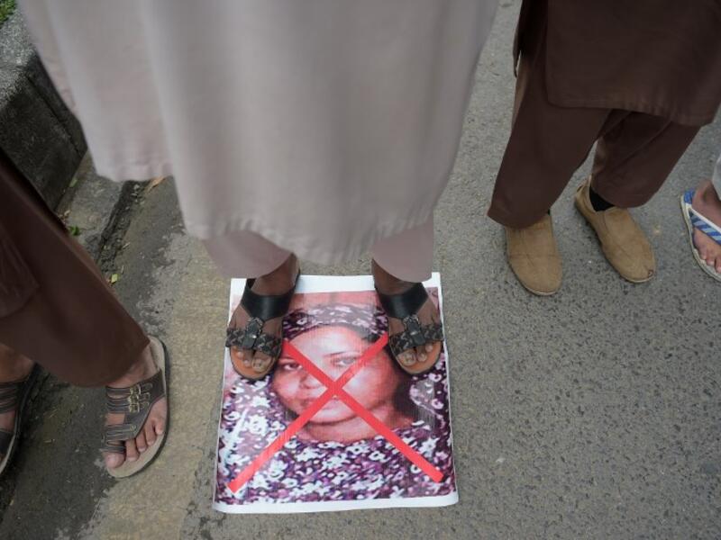 A Pakistani supporter of the Ahle Sunnat Wal Jamaat (ASWJ) stands over an image of Christian woman Asia Bibi. (AAMIR QURESHI / AFP)