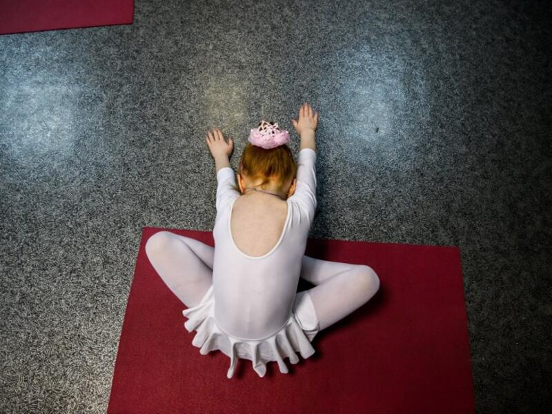 A girl attends a class at a ballet studio in Moscow on November 22, 2018. In a small studio in northern Moscow, parents and grandparents sit in a corridor waiting for children as young as three to finish their ballet class. 
Mladen ANTONOV / AFP