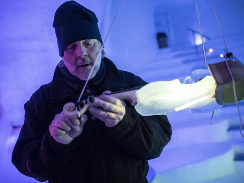 US artist Tim Linhart works on an ice violin in the "Ice Dome" on Presena Galcier, Tonale Pass, near Trento in northern Italy on January 18, 2018. 
Marco BERTORELLO / AFP
