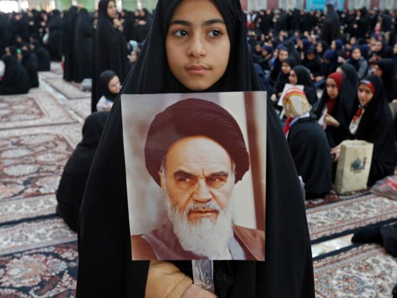 An Iranian girl holds a poster of Iran's late founder of the Islamic Republic, Ayatollah Ruhollah Khomeini. STR / AFP
