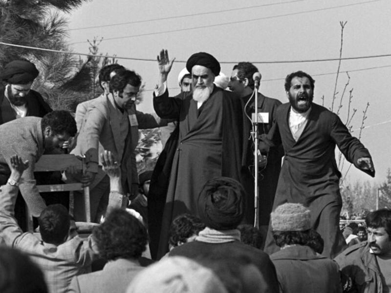 Ayatollah Ruhollah Khomeini waves to a crowd of supporters gathered at the Behechte Zahra Cemetery in Tehran during his visit on the day of his return from France after 15 years of exile. GABRIEL DUVAL / AFP

