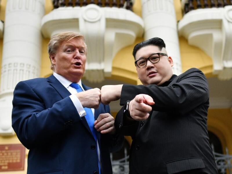 US President Donald Trump impersonator Russel White (L) and North Korean leader Kim Jong Un impersonator Howard X (R) pose together for photographs outside the Opera House in Hanoi on February 22, 2019. 
Manan VATSYAYANA / AFP