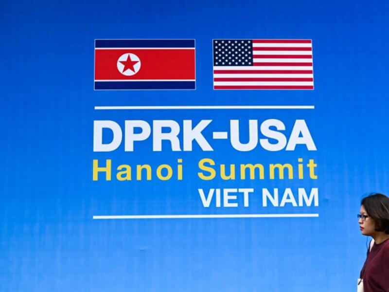 A woman walks past a billboard for the upcoming second summit between US President Donald Trump and North Korean leader Kim Jong Un, in Hanoi on February 24, 2019. 
Jewel SAMAD / AFP