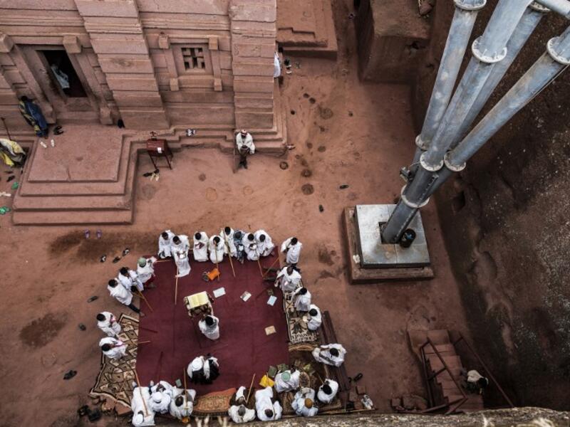 Ethiopian Orthodox devotees gather near the pillar of a shelter that protects the rock-hewn structure from erosion of the church of Saint Emmanuel in Lalibela, Ethiopia 
EDUARDO SOTERAS / AFP