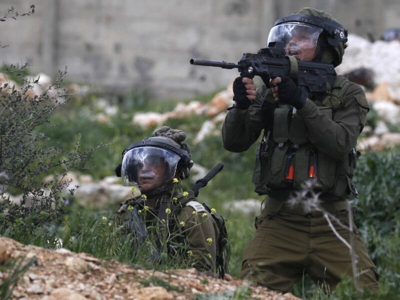 Israeli soldiers take aim at Palestinian protesters following a weekly demonstration against the expropriation of Palestinian lands in the village of Kfar Qaddum, near Nablus 
JAAFAR ASHTIYEH / AFP