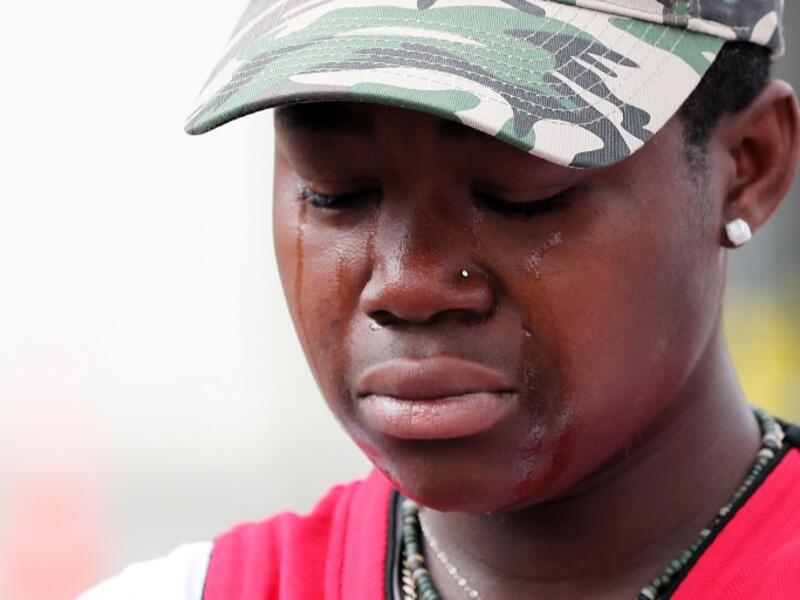 A young mourner weeps after placing flowers at the police cordon as Police conintue the search of the area close by the Linwood Ave Mosque in Christchurch 
MICHAEL BRADLEY / AFP