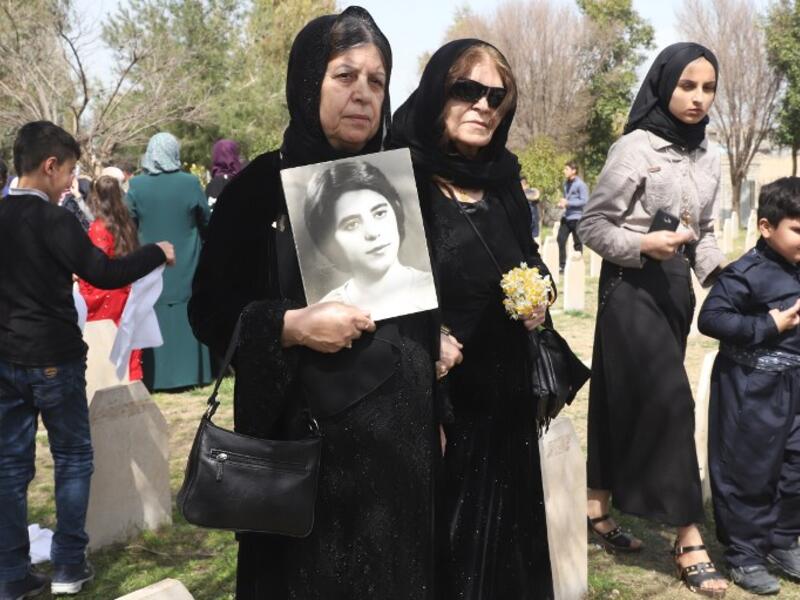 Iraqi-Kurds visit a grave site in Halabja near the monument for victims of the Halabja gas massacre 
Shwan MOHAMMED / AFP